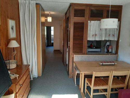 un salon avec une table et une cuisine dans l'établissement Family mountain apartment, à Tignes