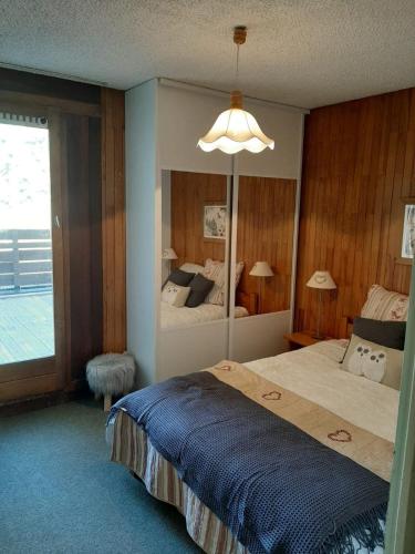 une chambre avec un grand lit et un grand miroir dans l'établissement Family mountain apartment, à Tignes