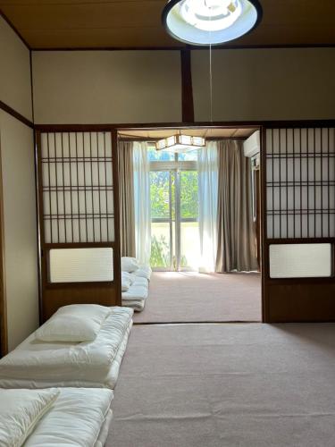 壹岐市一棟貸し民泊宿松山荘的带窗户的房间里的一排床