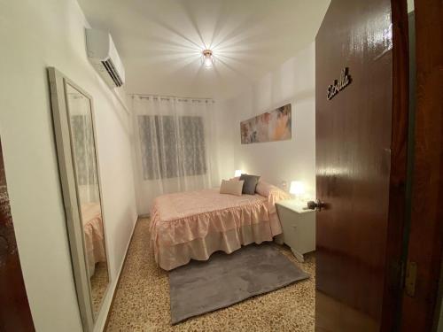 a small bedroom with a bed and a mirror at Ca la Pepa- Casa en Montiel- Ruta del Quijote in Montiel