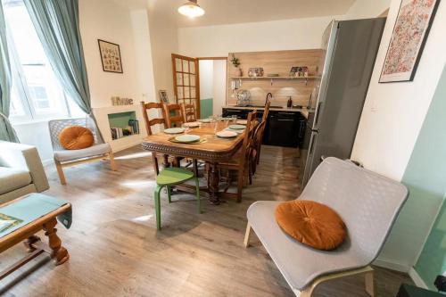 サン・テティエンヌにあるLa STÉPHANOISEのテーブルと椅子のあるキッチンとダイニングルーム