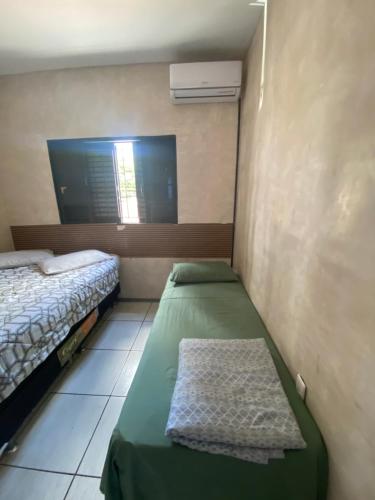 a small room with two beds and a window at Minas Hotel Uberlândia in Uberlândia