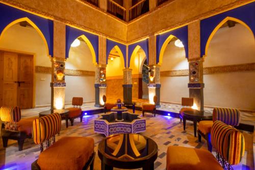a room with chairs and tables in a building at Riad AL MAKTOUB maison d'hotes écologique in Marrakech