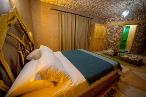 a bedroom with a large bed in a room at Riad AL MAKTOUB maison d'hotes écologique in Marrakech