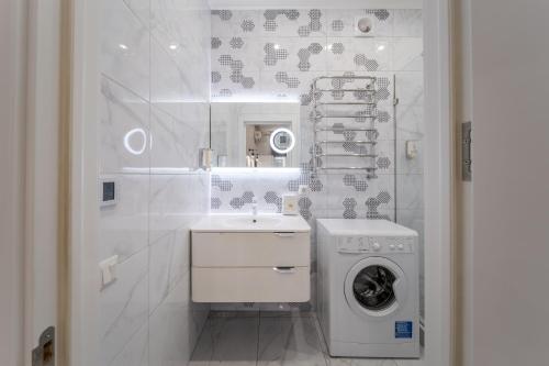 une salle de bains blanche avec un lave-linge et un lave-linge. dans l'établissement Royal apartment on Lysenka 5, à Lviv