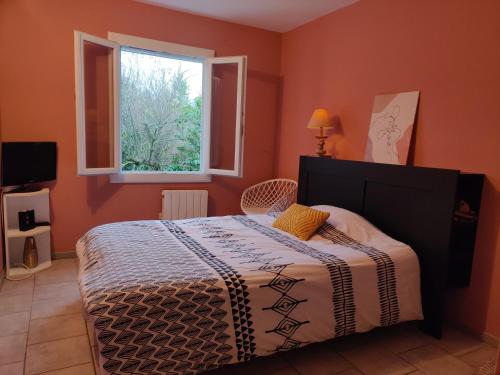 une chambre avec un lit et une fenêtre dans l'établissement Villa Caroux, à Bédarieux