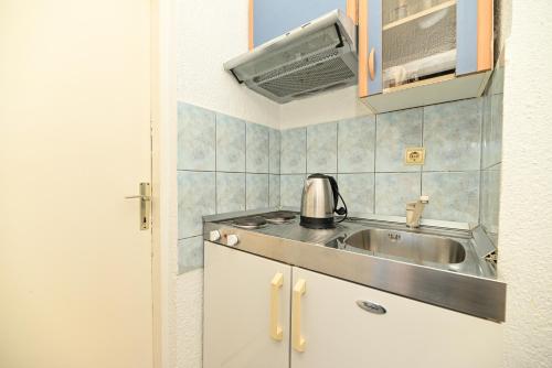 a kitchen with a sink and a microwave at Apartments Marić in Primošten