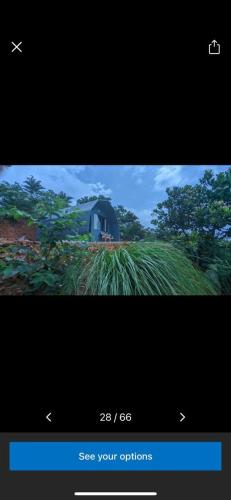 a television screen with a picture of a blue house at Spirit of the Wild Eco Village in Palakkad