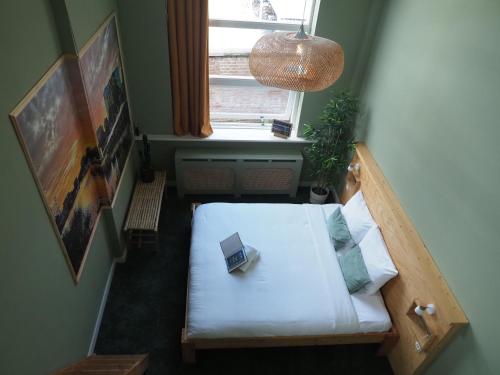 a small room with a bed and a window at Hostel Roots in Tilburg