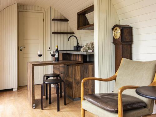 a kitchen with a table and a clock and chairs at The Forest at Mount Congreve Gardens in Kilmeaden