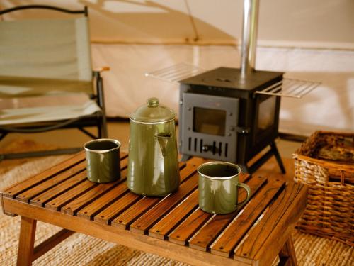 a table with two coffee mugs and a stove at The Forest at Mount Congreve Gardens in Kilmeaden
