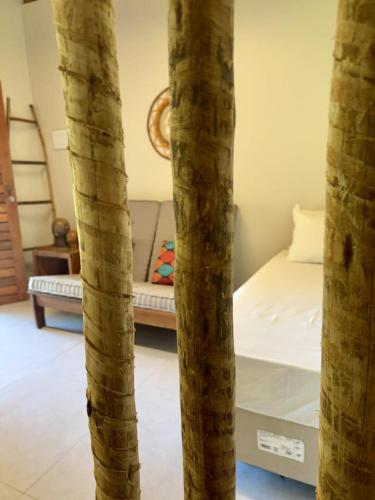 a bedroom with a bed and two palm trees at Angá Beach Hotel in São Miguel dos Milagres