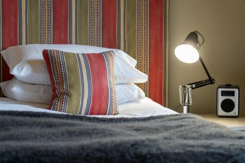 a bed with a pillow and a lamp on a table at The Pier Hotel in Harwich
