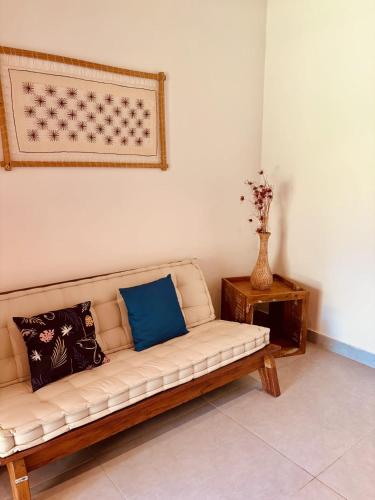 a white couch with blue pillows in a room at Angá Beach Hotel in São Miguel dos Milagres