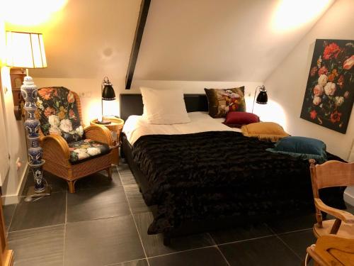 a bedroom with a bed and a chair at The Black Horse B&B & More in Drachten