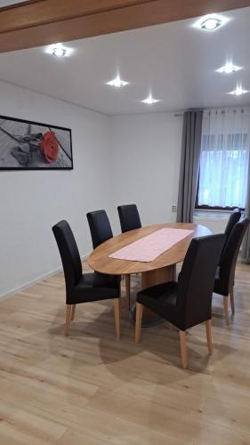 a dining room with a wooden table and chairs at Haus Linde in Westerburg