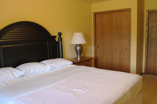 a bedroom with a bed with a black headboard and a lamp at 2 Bedroom Condo at Wild Eagle Lodge, #212 in Eagle River