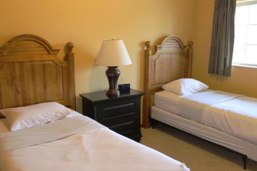 a bedroom with two beds and a lamp on a night stand at 2 Bedroom Condo at Wild Eagle Lodge, #212 in Eagle River