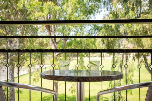 a glass table in front of a screened porch with a window at Mitsis Messonghi in Moraitika