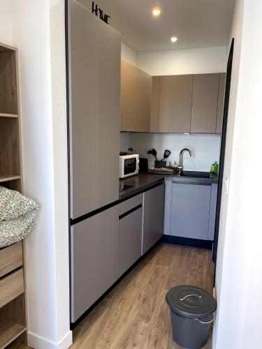  La cuisine est équipée de placards blancs et d'un réfrigérateur. dans l'établissement Joli Studio Place Garibaldi, Vieux-Nice, Port, à Nice