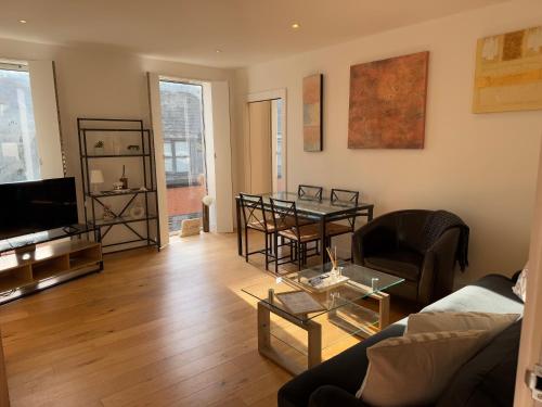 a living room with a couch and a table at Central, modern and peaceful, lovely Cathedral views, two-bed apartment with 40" smart TV & free onsite parking in Lincoln