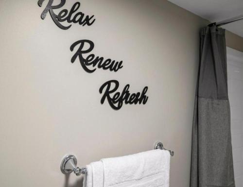 a bathroom with a sign that reads renew refresh on the wall at Upscale Studio in NY with Kitchen & Serene Setting in Congers