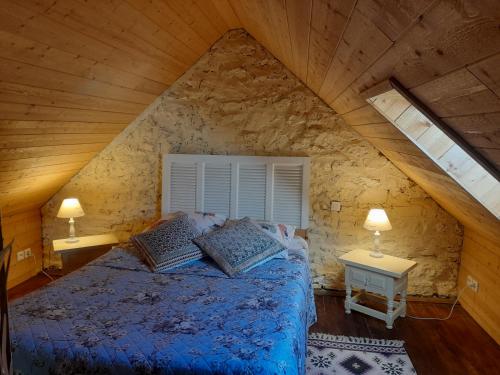 a bedroom with a bed in a stone wall at Le cottage in Crozon