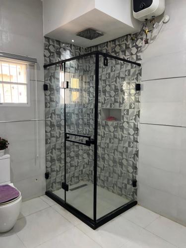 a shower with a glass door in a bathroom at Exotic 3 bedroom flat in Aco, Lugbe in Abuja