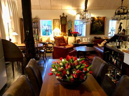 a room with a table with a bowl of flowers on it at The Black Horse B&B & More in Drachten