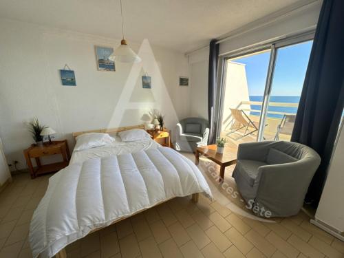 une chambre avec un lit, une chaise et une fenêtre dans l'établissement 40 M², 1ERE LIGNE MER, DERNIER ETAGE AVEC ASCENSEUR, à Sète