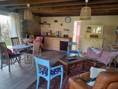 un salon avec un canapé, une table et des chaises dans l'établissement Le cottage, à Crozon