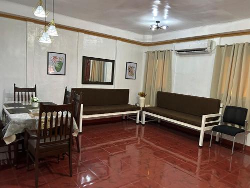 a living room with two couches and a table and chairs at ACL Staycation Home in Imus & Kawit with mini pool Unit 3 in Kawit