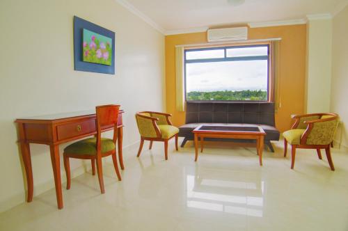 a living room with a table and chairs and a window at Gran Hotel De Lago - El Coca in Puerto Francisco de Orellana