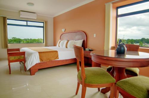 a bedroom with a bed and a table and a window at Gran Hotel De Lago - El Coca in Puerto Francisco de Orellana