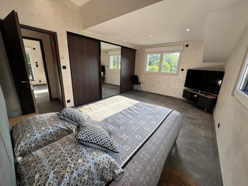 une chambre avec un grand lit et une télévision à écran plat dans l'établissement Le Logis des Fées, à Gérardmer