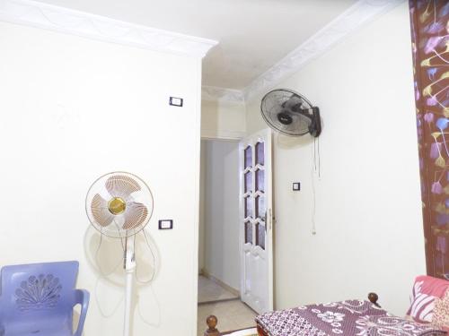 a room with a fan and a blue chair at برج بيلو بيتش in Alexandria