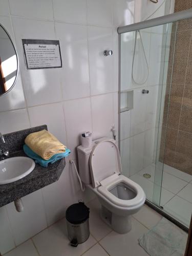 a bathroom with a shower and a toilet and a sink at Pousada Recanto do Japa in Nilo Peçanha