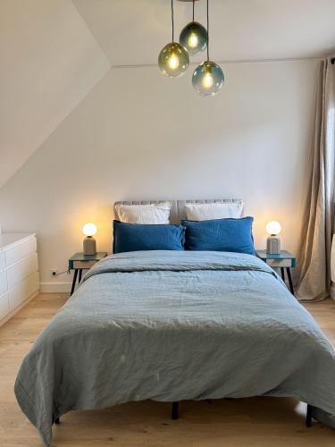 une chambre avec un grand lit avec des oreillers bleus dans l'établissement Modern and Quiet House with Patio, à Saint-Ouen