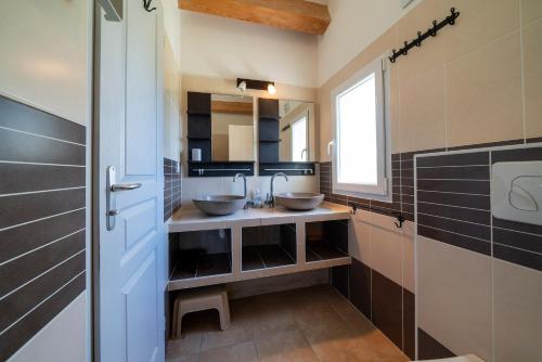 une salle de bain avec deux lavabos et une fenêtre dans l'établissement Résidence Au Brin d'Olivier, à Saint-Martin-dʼArdèche