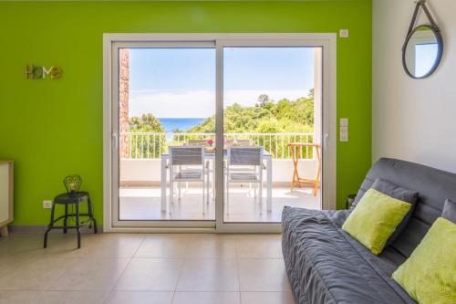 d'un salon avec un canapé et d'un balcon avec une table. dans l'établissement Studio Aloe - Welkeys, à Cavalaire-sur-Mer