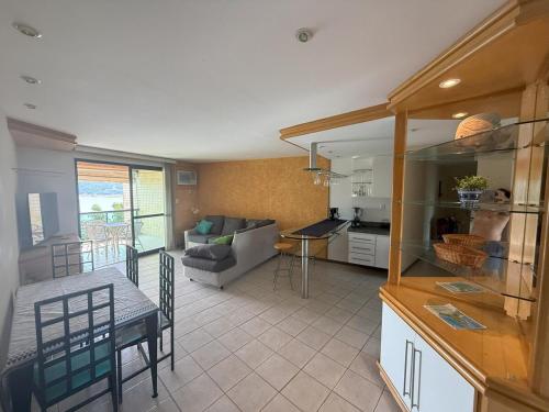 a kitchen and living room with a couch and a table at Porto Real Resort - Apto 3 Suites - Por do Sol Genial in Mangaratiba