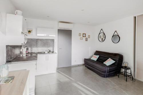 un salon avec un canapé et une cuisine dans l'établissement Studio Bougainvillier - Welkeys, à Cavalaire-sur-Mer