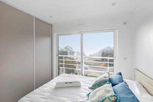 une chambre avec un lit et une grande fenêtre dans l'établissement Appartement Dattier - Welkeys, à Cavalaire-sur-Mer