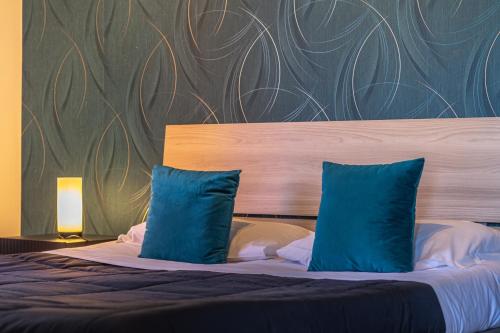 a bedroom with a bed with two blue pillows at Katrina's Home alloggio turistico in Fiumicino