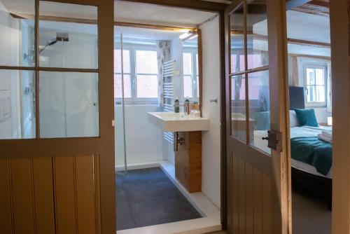 a bathroom with a shower and a sink next to a bed at Haus im Zitronengässele in Lindau