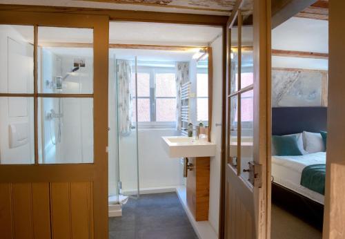 a bathroom with a sink and a shower and a bed at Haus im Zitronengässele in Lindau