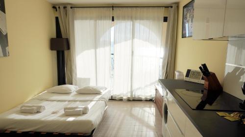 deux lits dans une petite pièce avec une fenêtre dans l'établissement Appartement 607, vue mer, 4 personnes By Palmazur Vacances, à Cannes