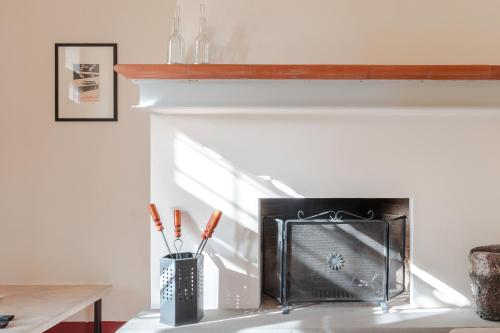 a fireplace with a metal container with toothbrushes in it at Borgo Syrah in Cortona