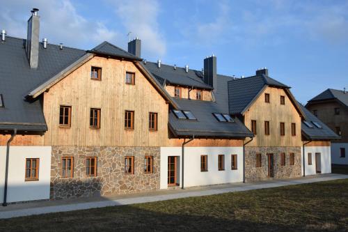 a large wooden building with black roof at Apartment U Lipna Nová Pec in Nová Pec