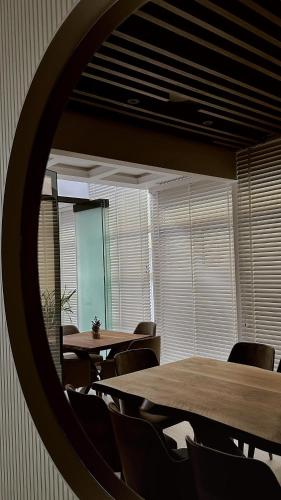 a room with tables and chairs and a mirror at Hotel Queen in Tirana